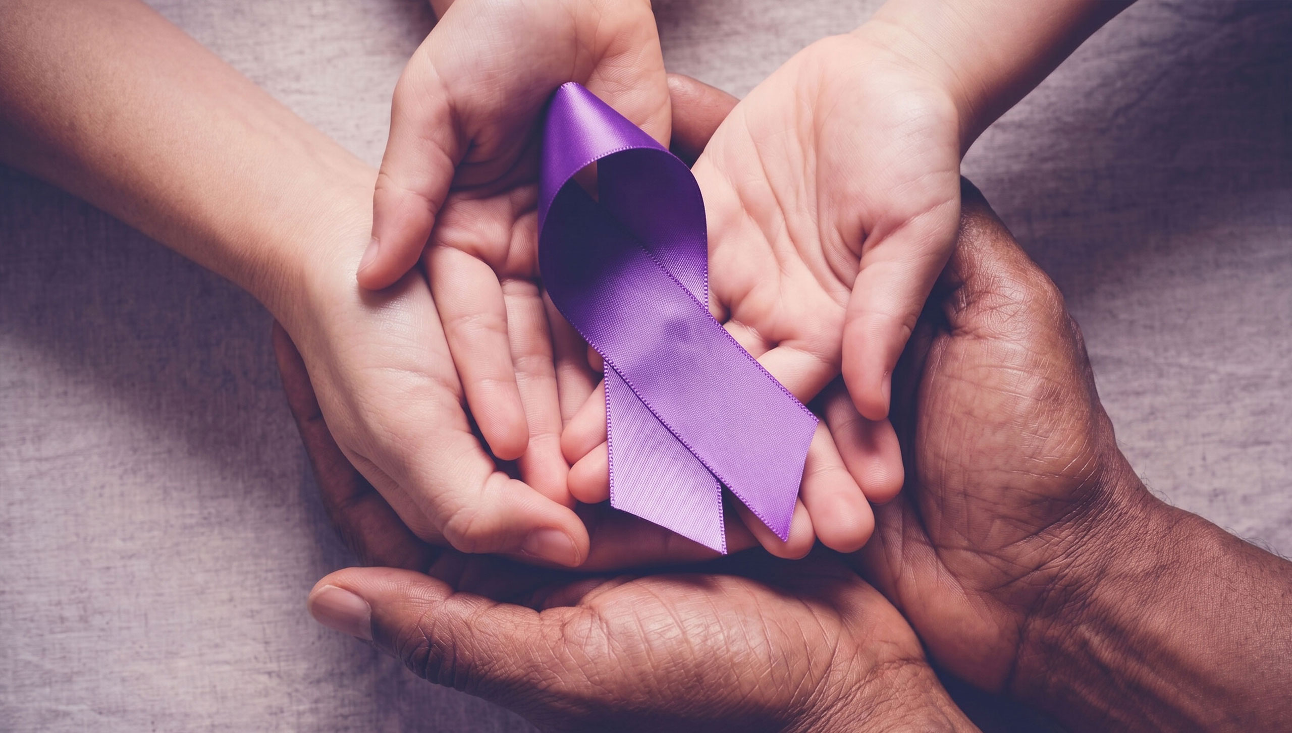 hands holding a ribbon aid to victims of volence ywca cortland