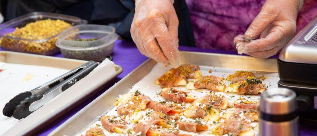 person preparing apple slices with gourmet toppings